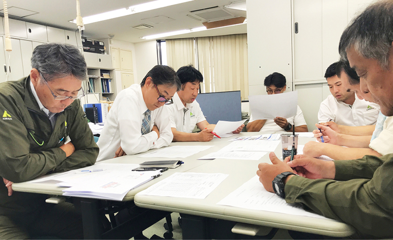 事務所で図面や資料を確認しながら打ち合わせをする様子